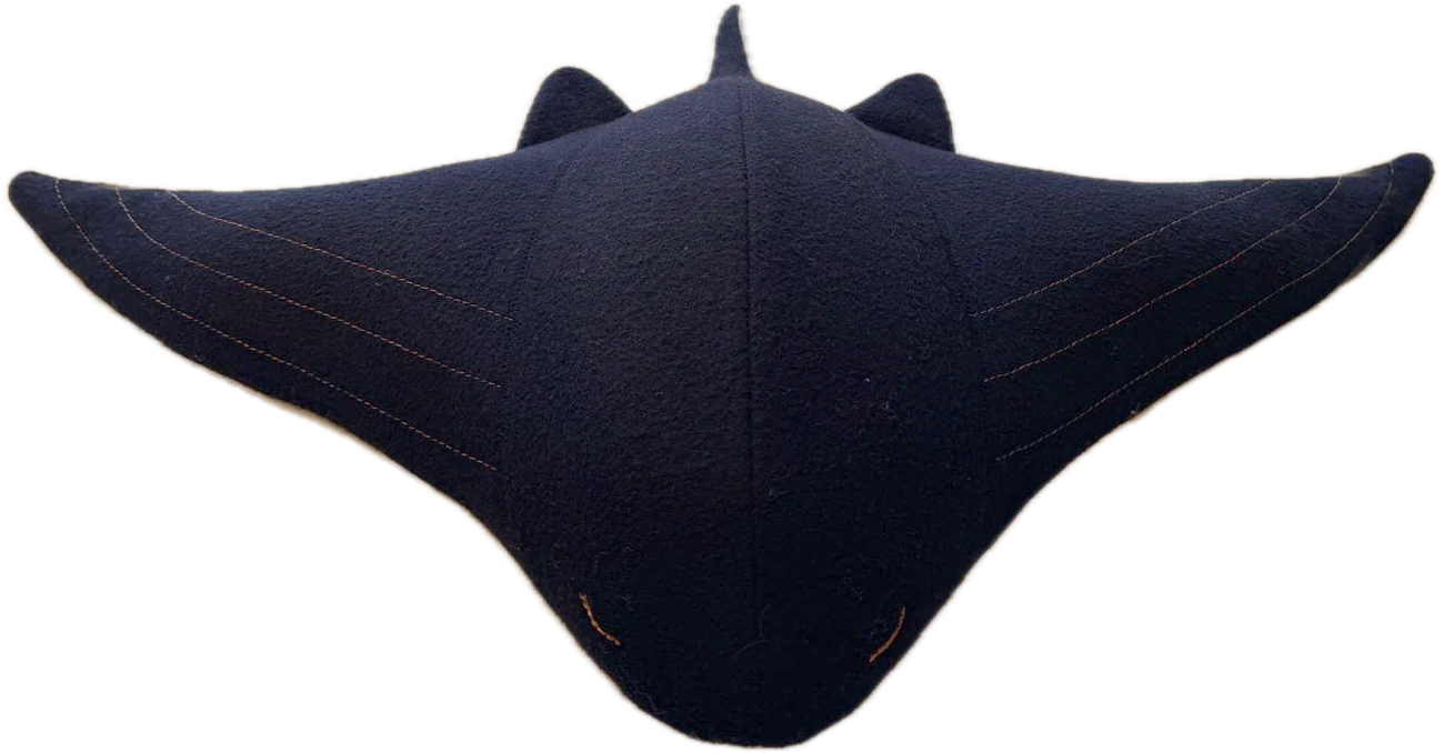 Cove from the front: navy wool, a raised centre body, broad wings with three copper stitch lines each, and two small closed-eye stitches at the nose